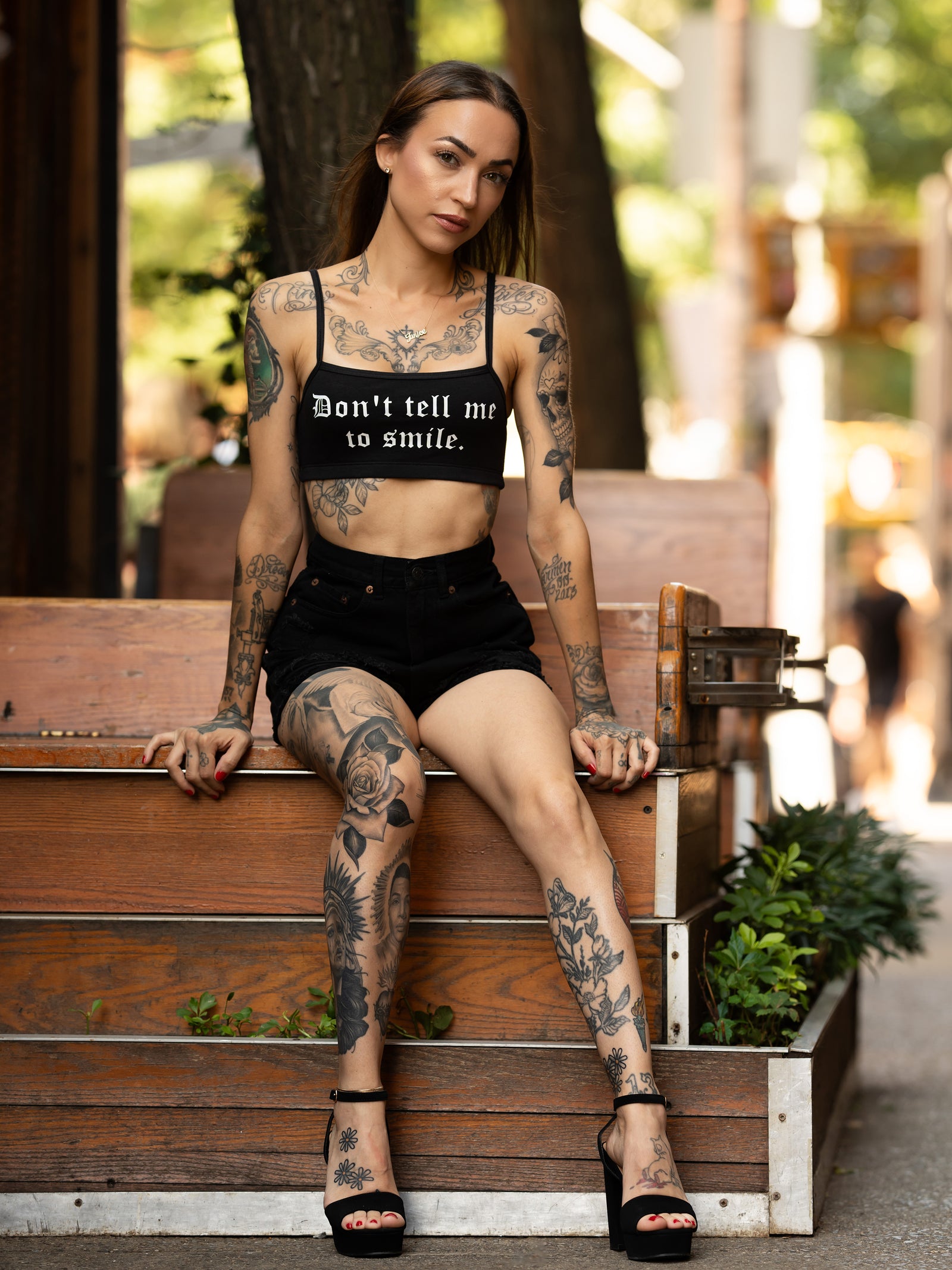 Janice Danger wearing a "Dont Tell Me To Smile" black bralette with black denim shorts