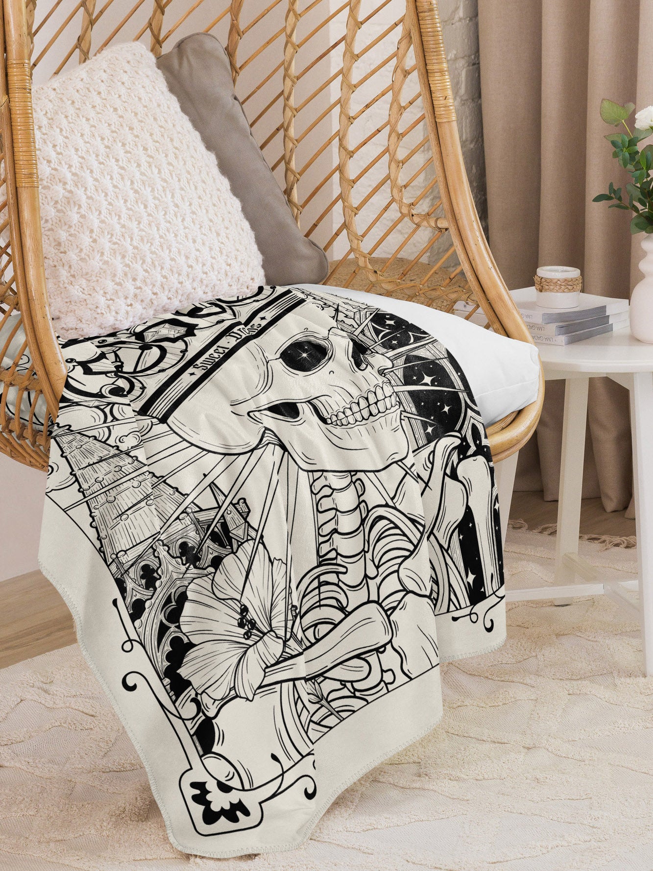 Sweet Dreams blanket draped over a hanging wicker chair. This portion of the design features flowers and a skeleton.