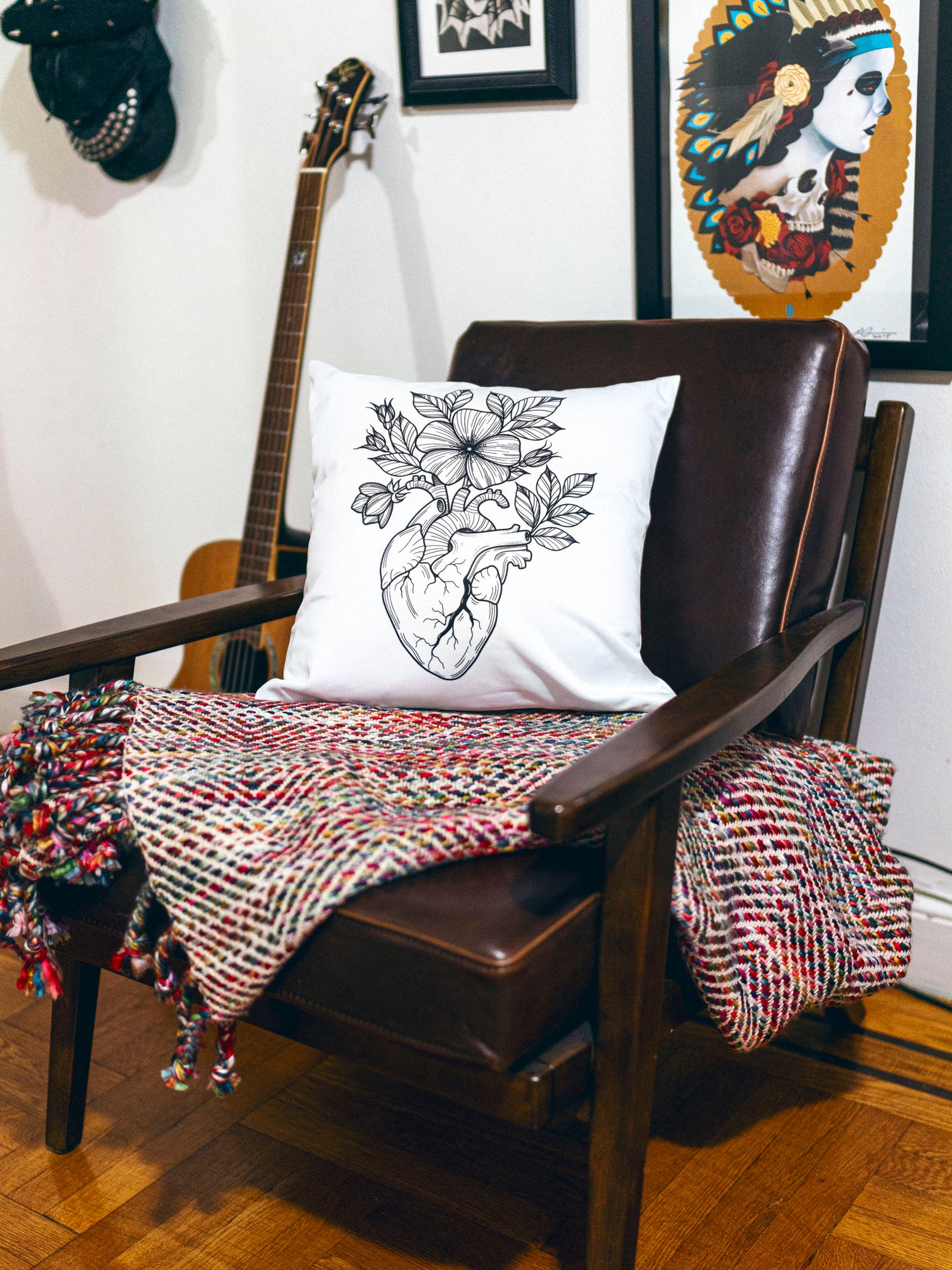 White throw pillow with black illustrative anatomical heart design by Janice Danger photographed in a homey setting.