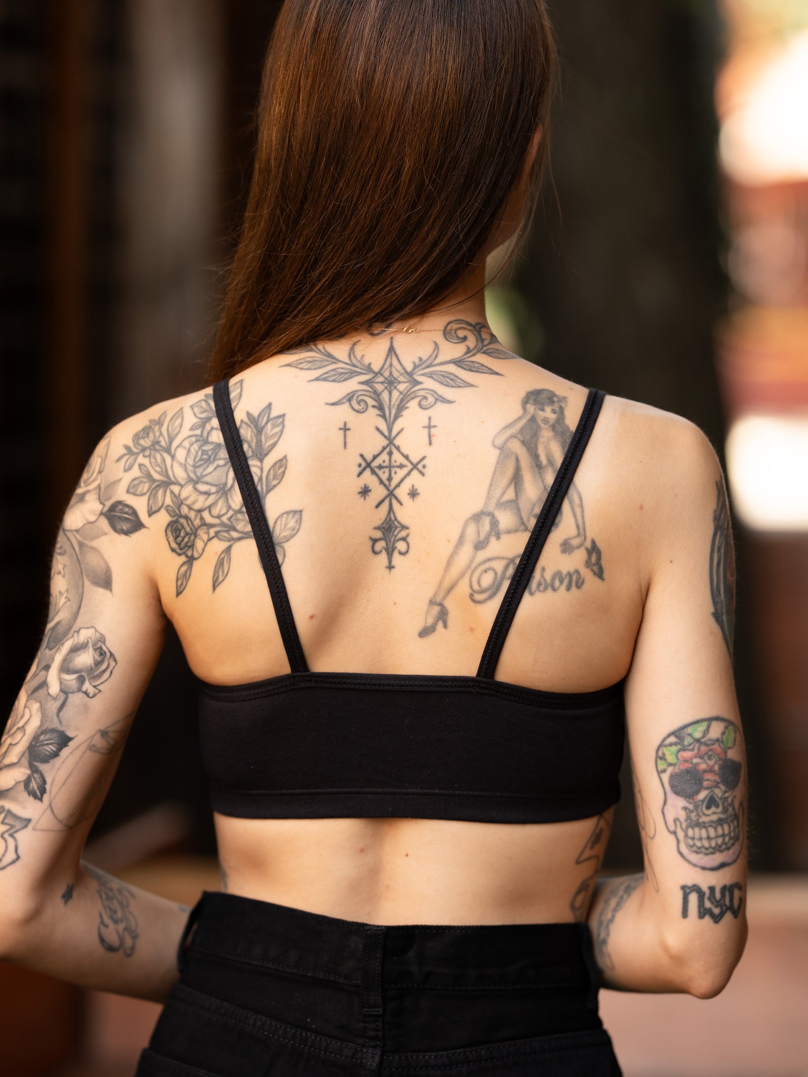 Back detail of the "dont tell me to smile" black bralette featuring two thin straps. 