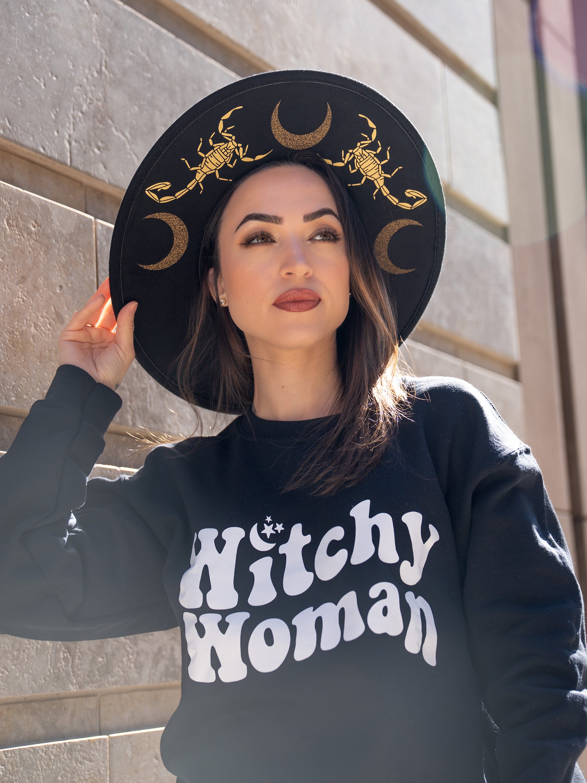Janice Danger wearing the Witchy Woman black crewneck featuring a 70's style Witchy Woman graphic. 