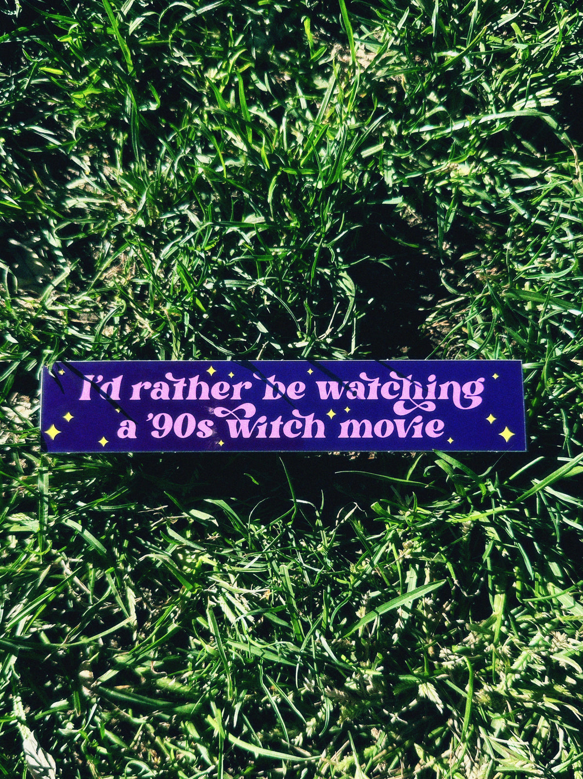 Purple bumper sticker with text on grass