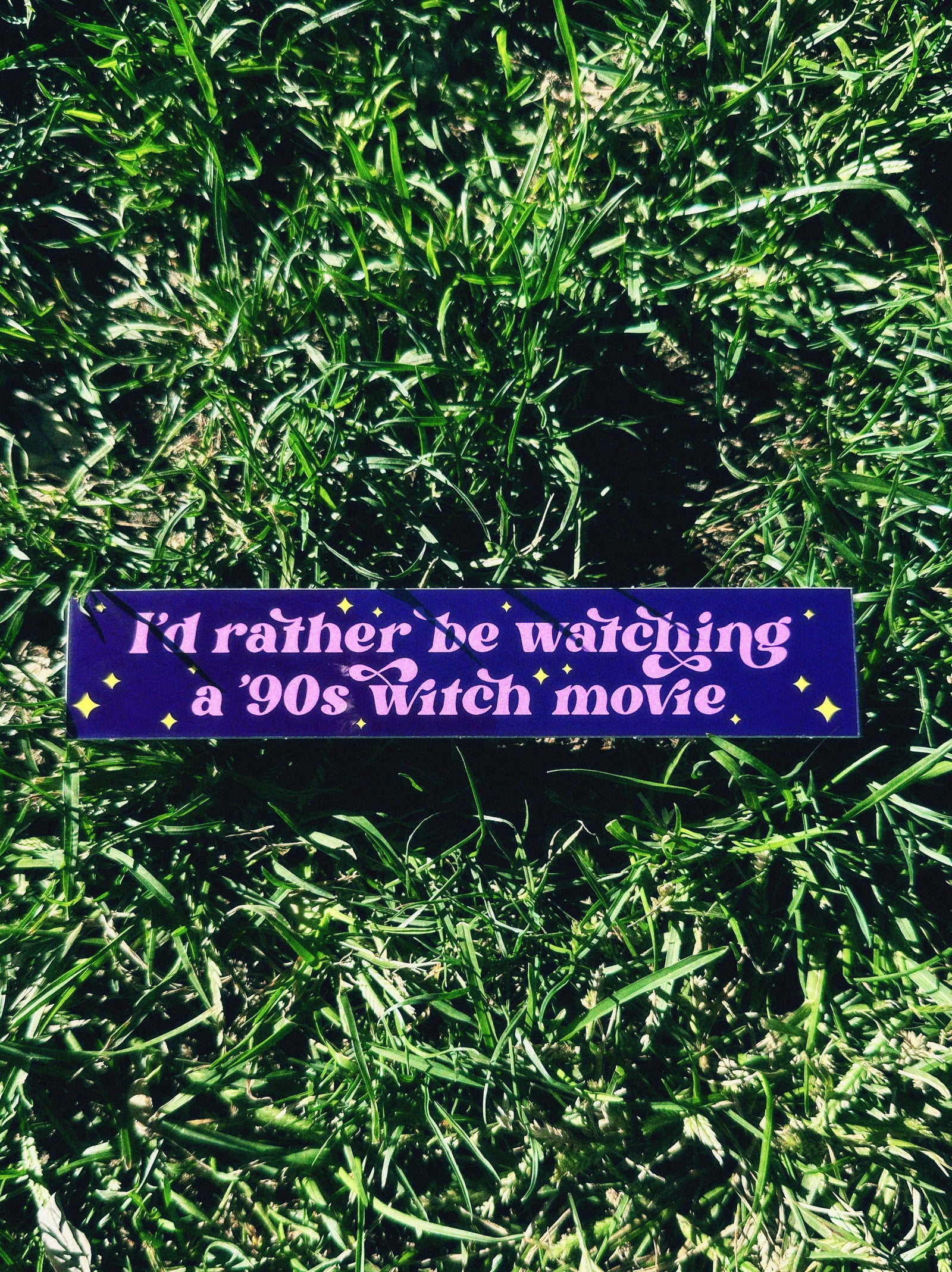 Purple bumper sticker with text on grass