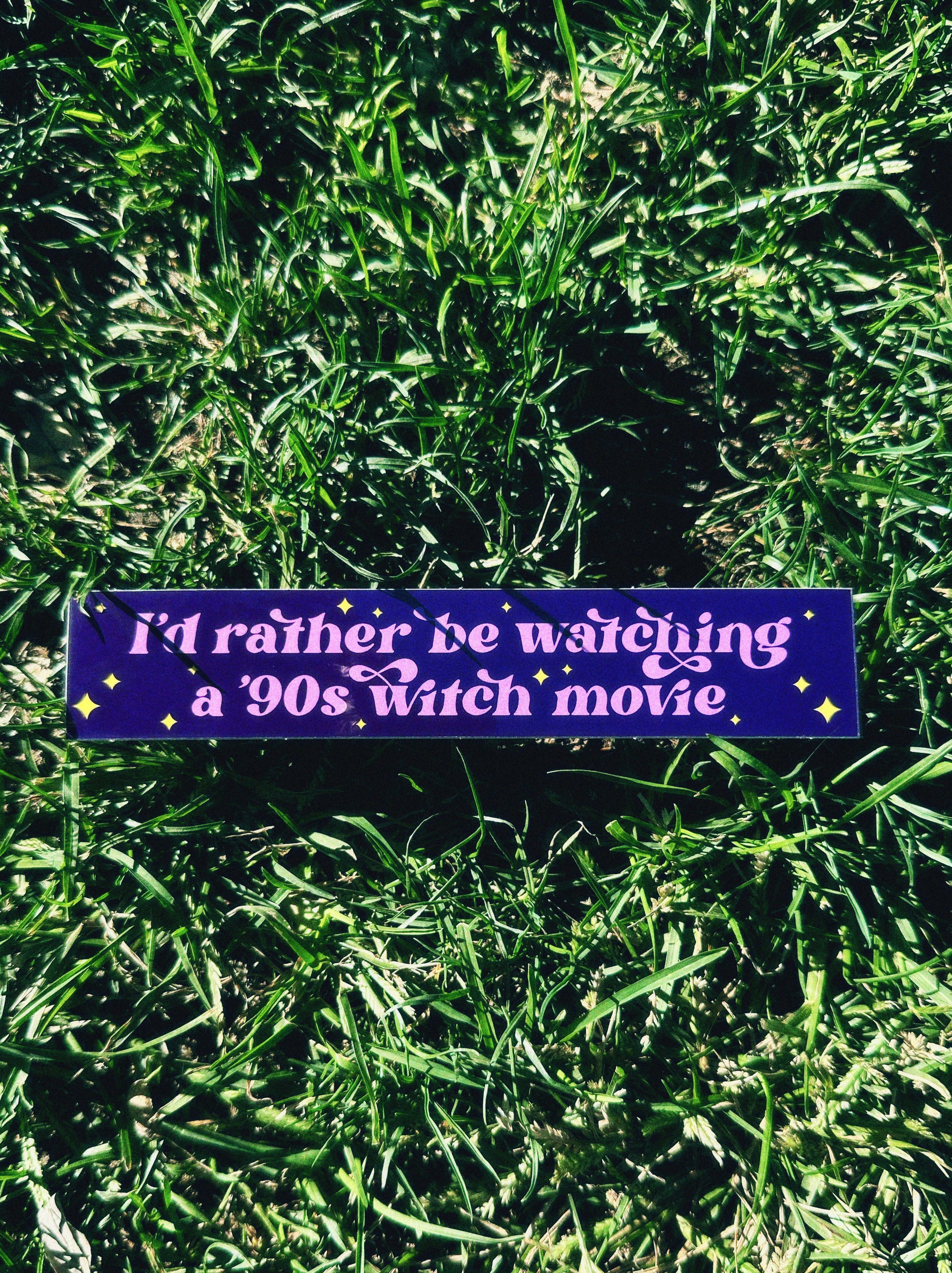 Purple bumper sticker with text on grass