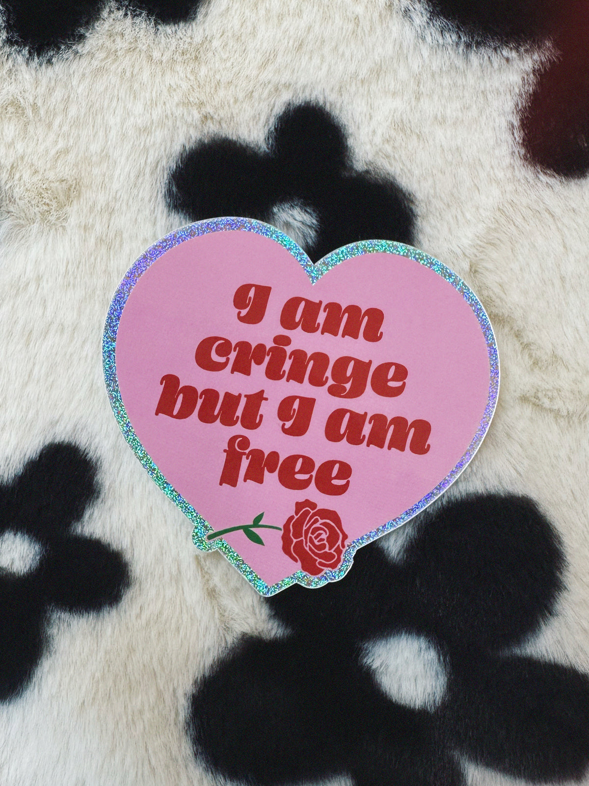 Heart-shaped pink sticker with text and a rose on a textured background
