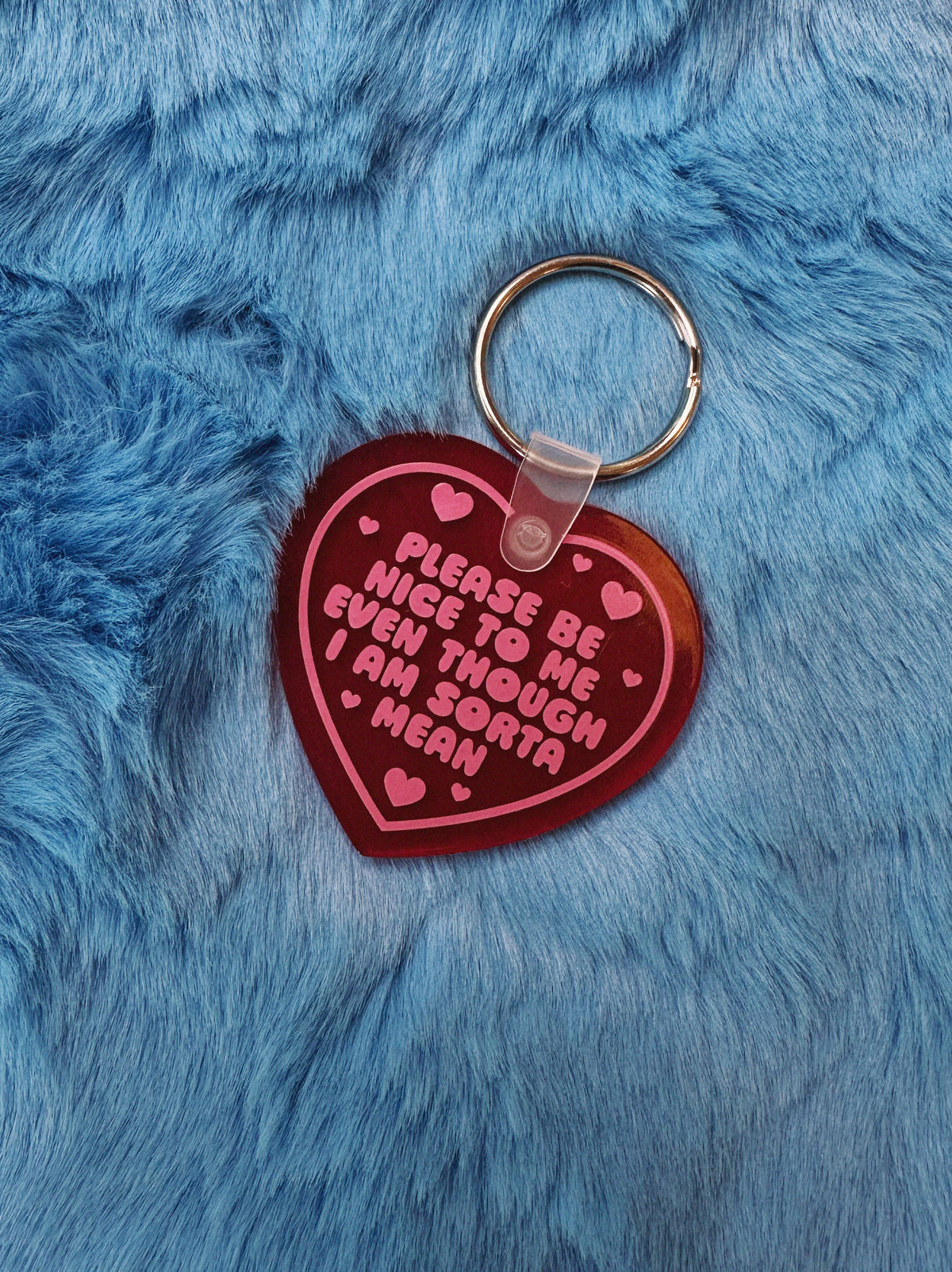 Heart-shaped keychain with pink text on a blue furry background