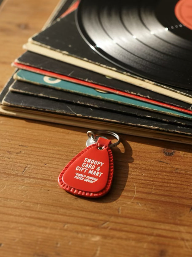 Red saddle style keychain with a white snoopy in a heart graphic on a white fur background
