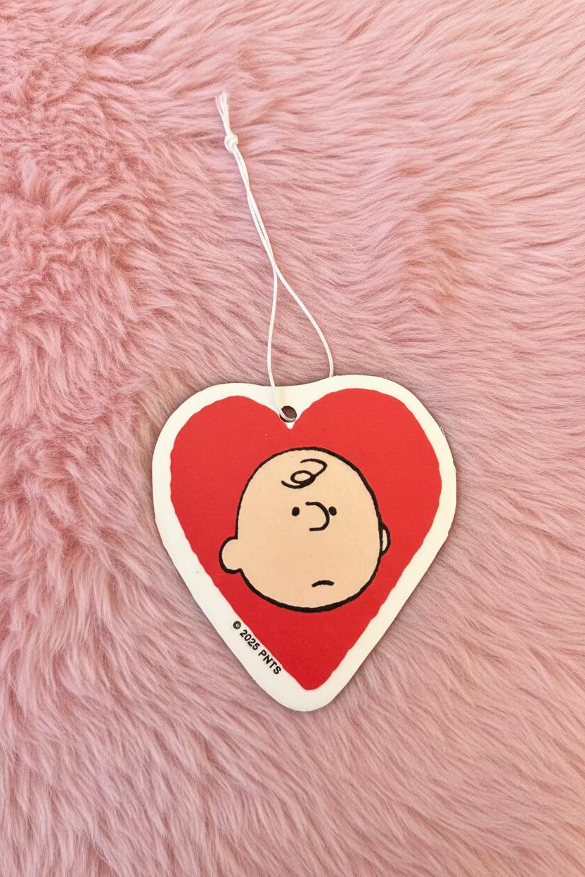 Heart-shaped air freshener with Charlie Brown in a red heart on a pink fuzzy background