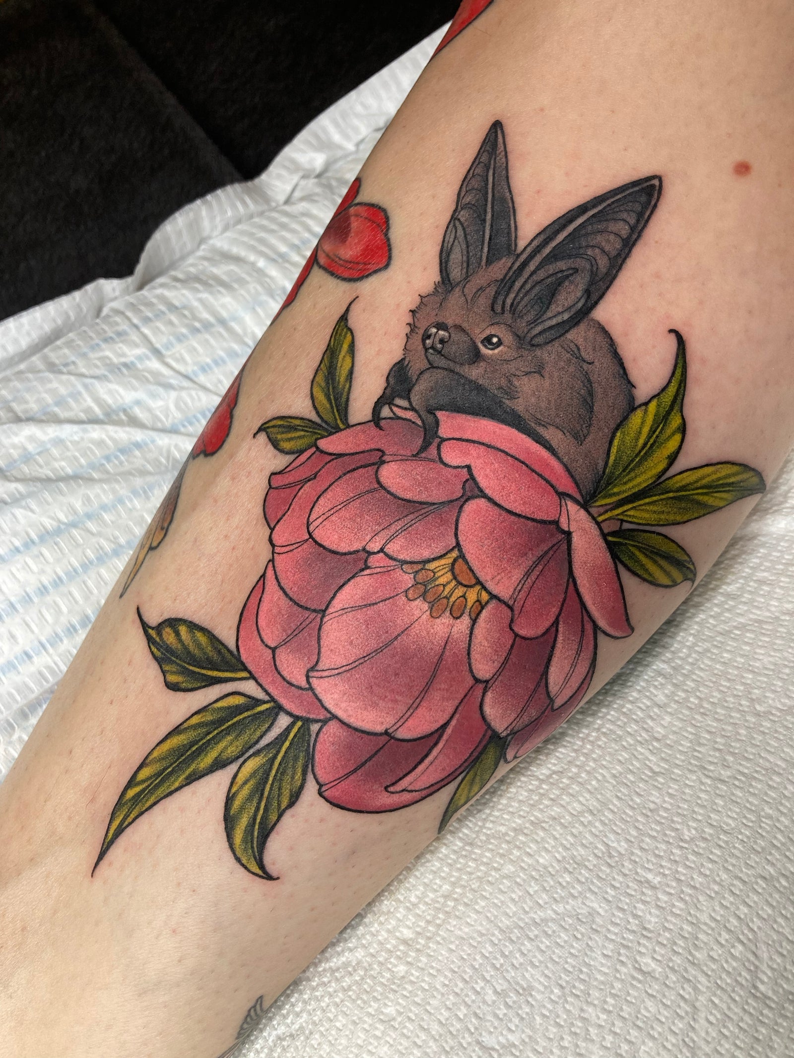 Neo traditional color bat tattoo featuring a pink flower with green leaves. Tattoo made by Charlotte Timmons at Grit n Glory in New York City.
