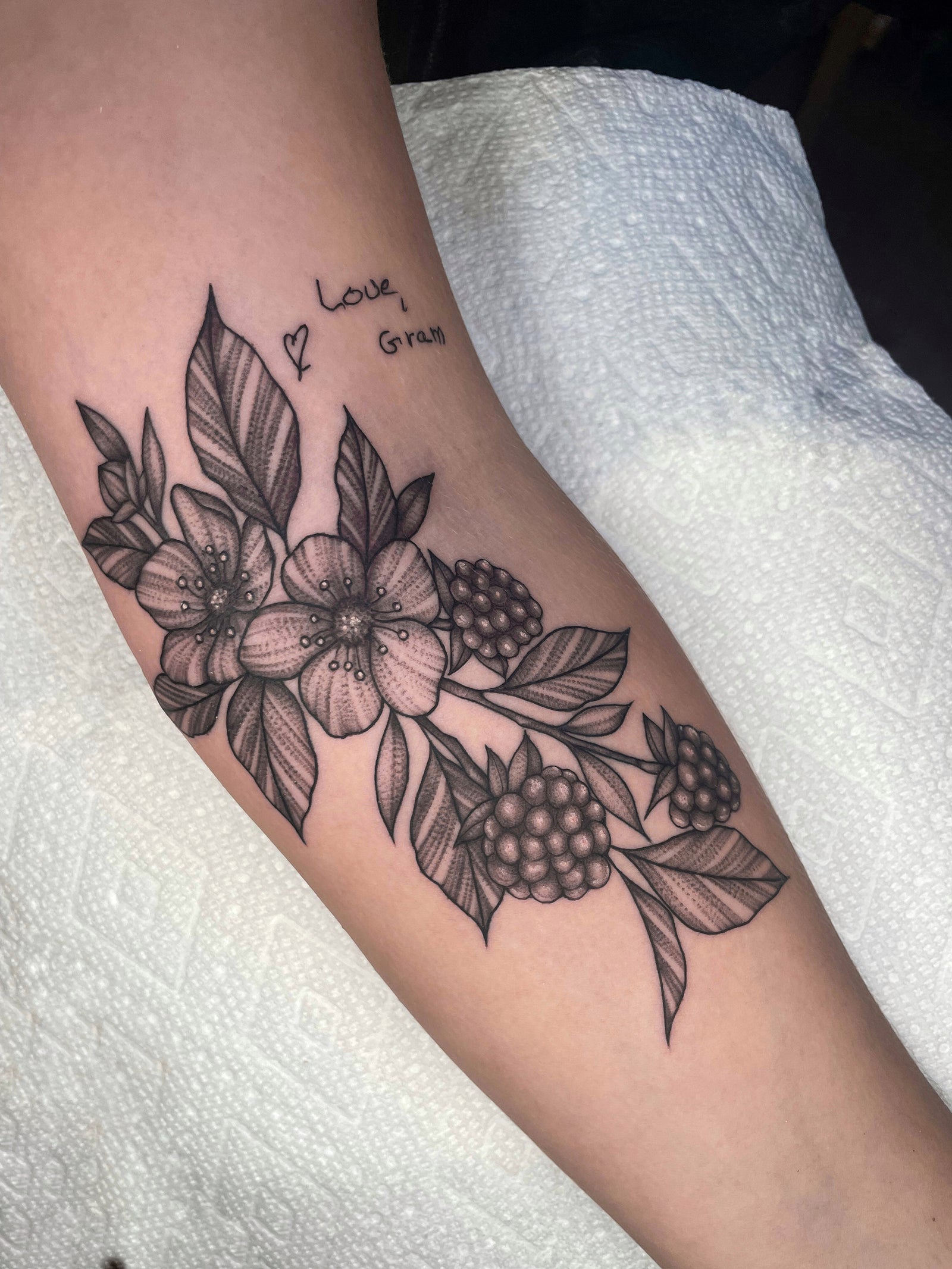 delicate floral and berry forearm tattoo by Janice Danger