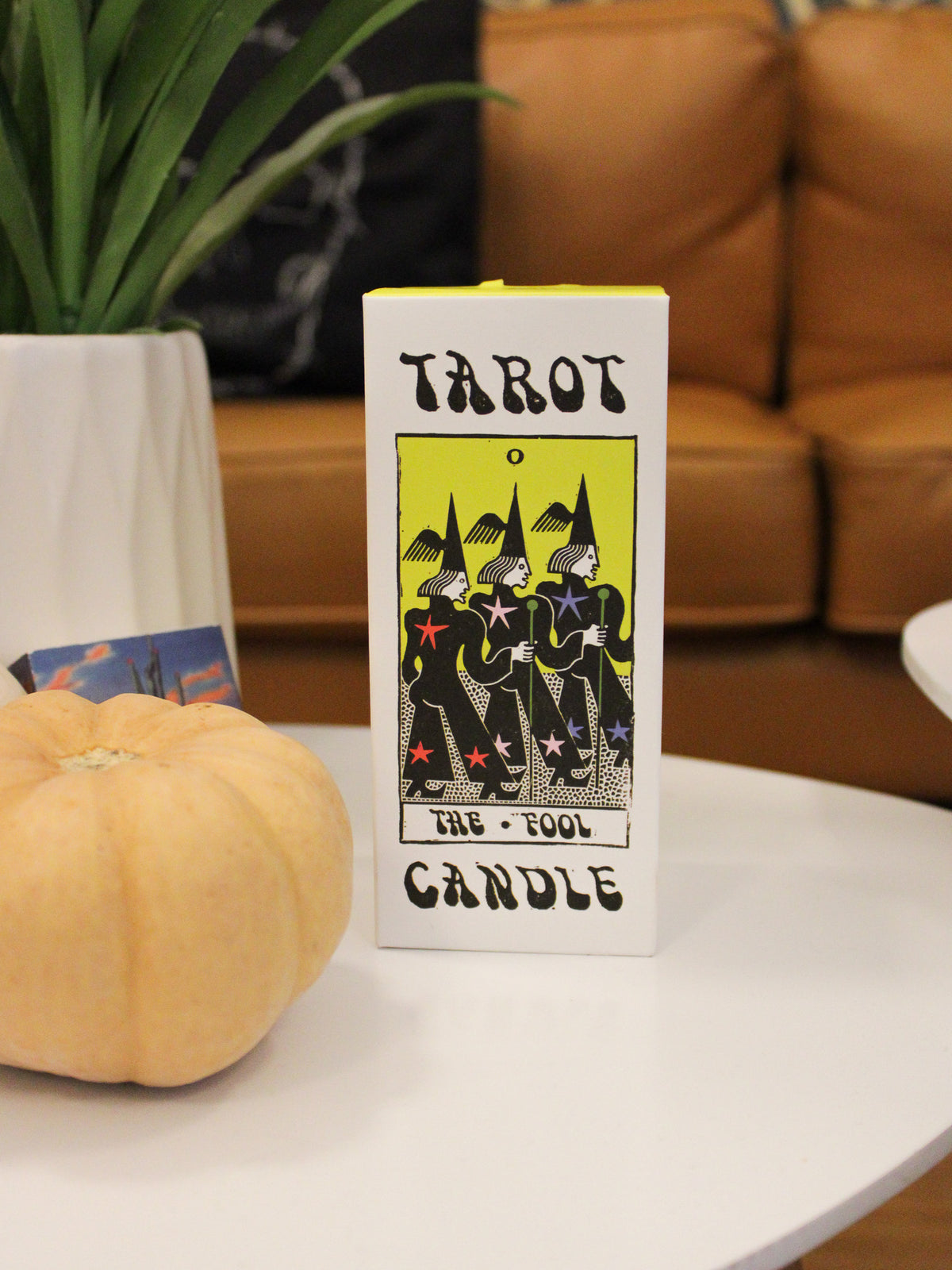Gift box details of votive candle; a white and yellow box with Tarot Candle The Fool Illustration