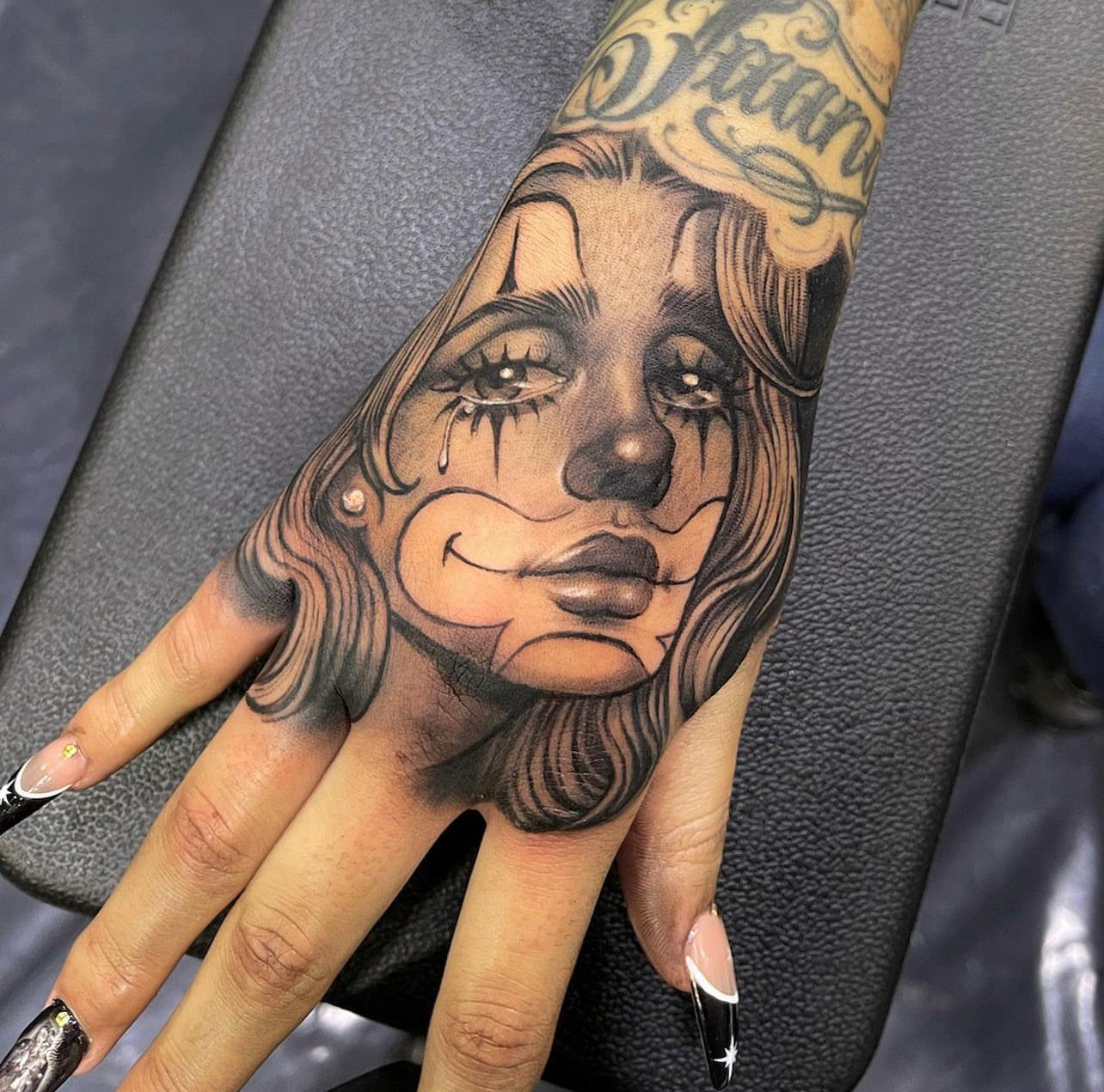 black and gray clown girl hand tattoo by Elvia Guadian