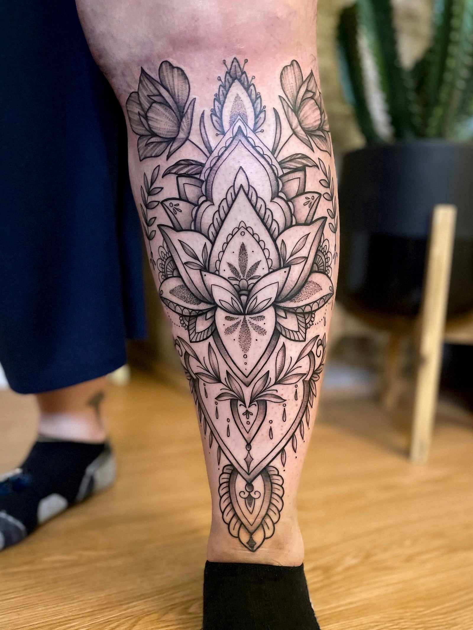 Delicate blackwork ornamental and floral shin, lower leg tattoo by Janice Danger