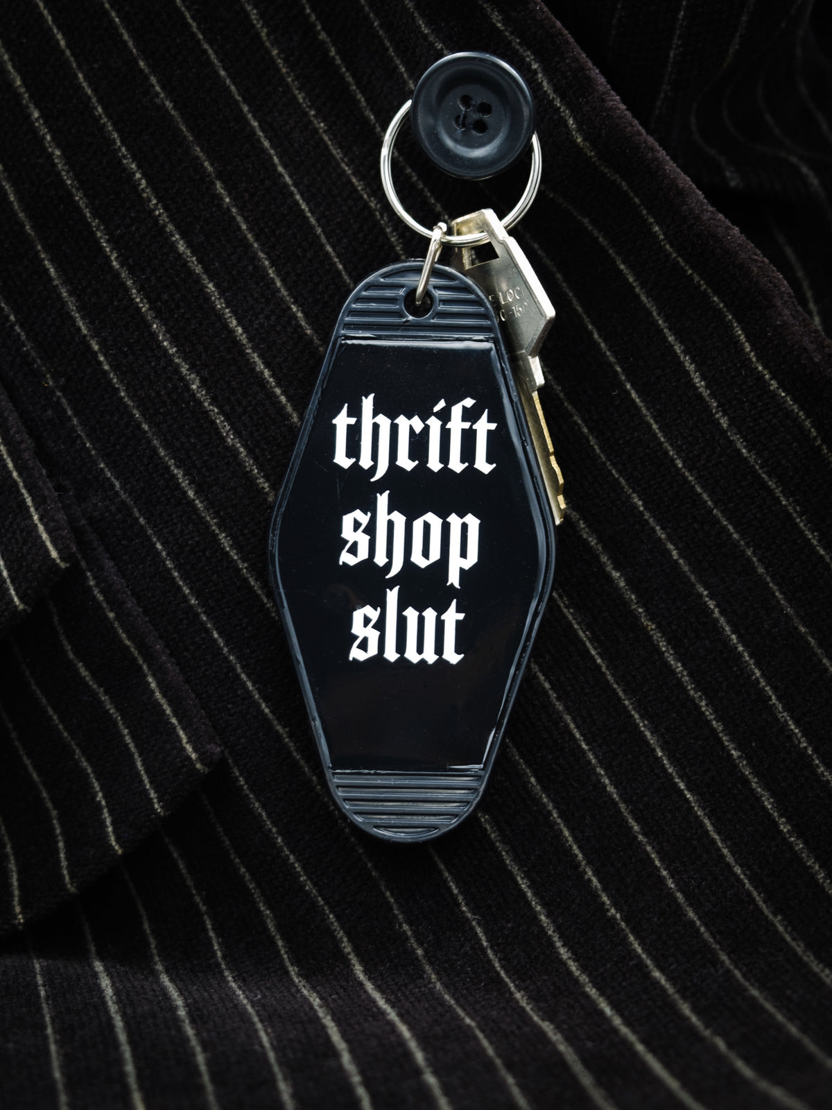 Motel style black keychain that reads &quot;thrift shop slut&quot; in white