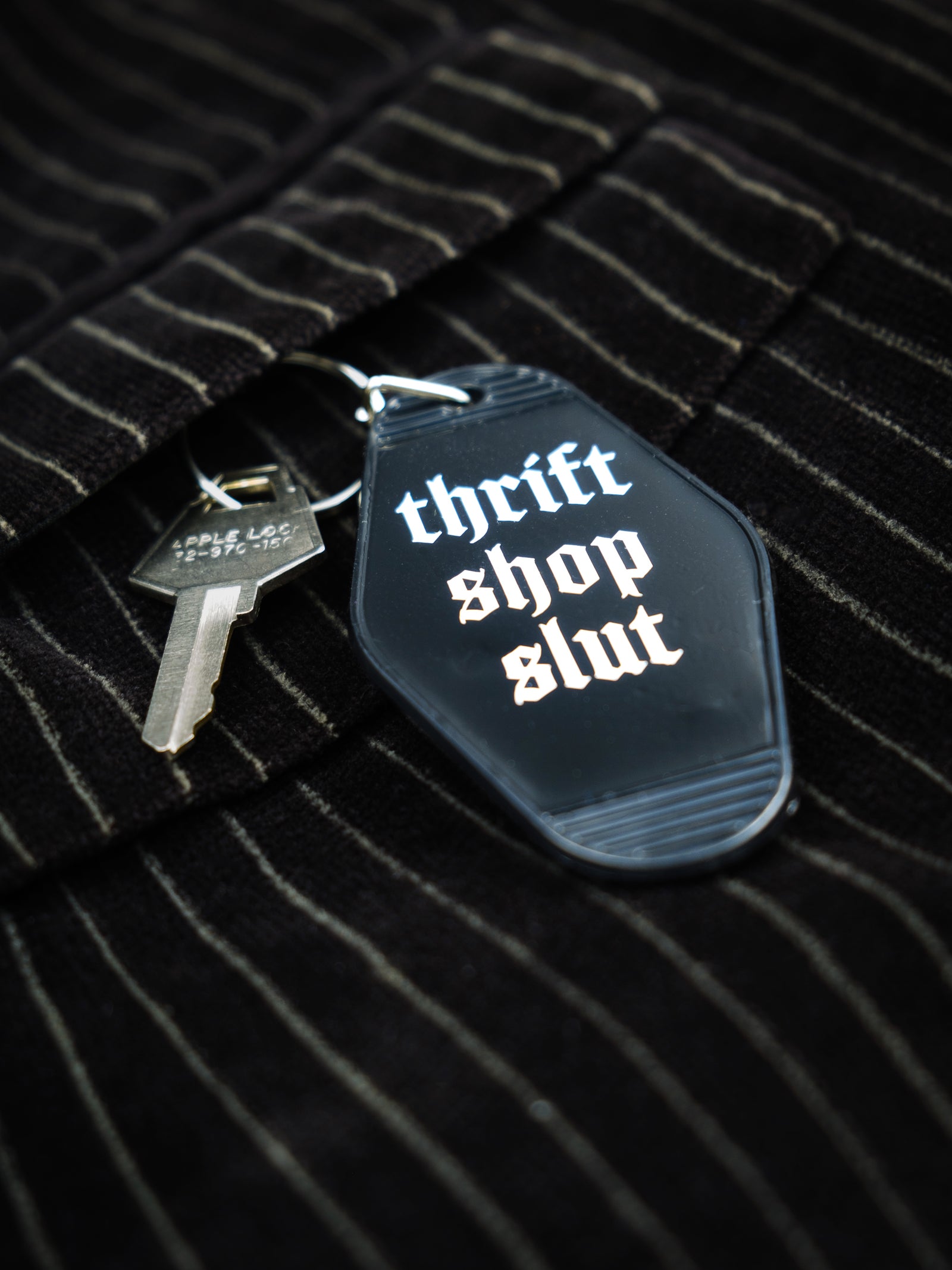 Motel style black keychain that reads "thrift shop slut" in white