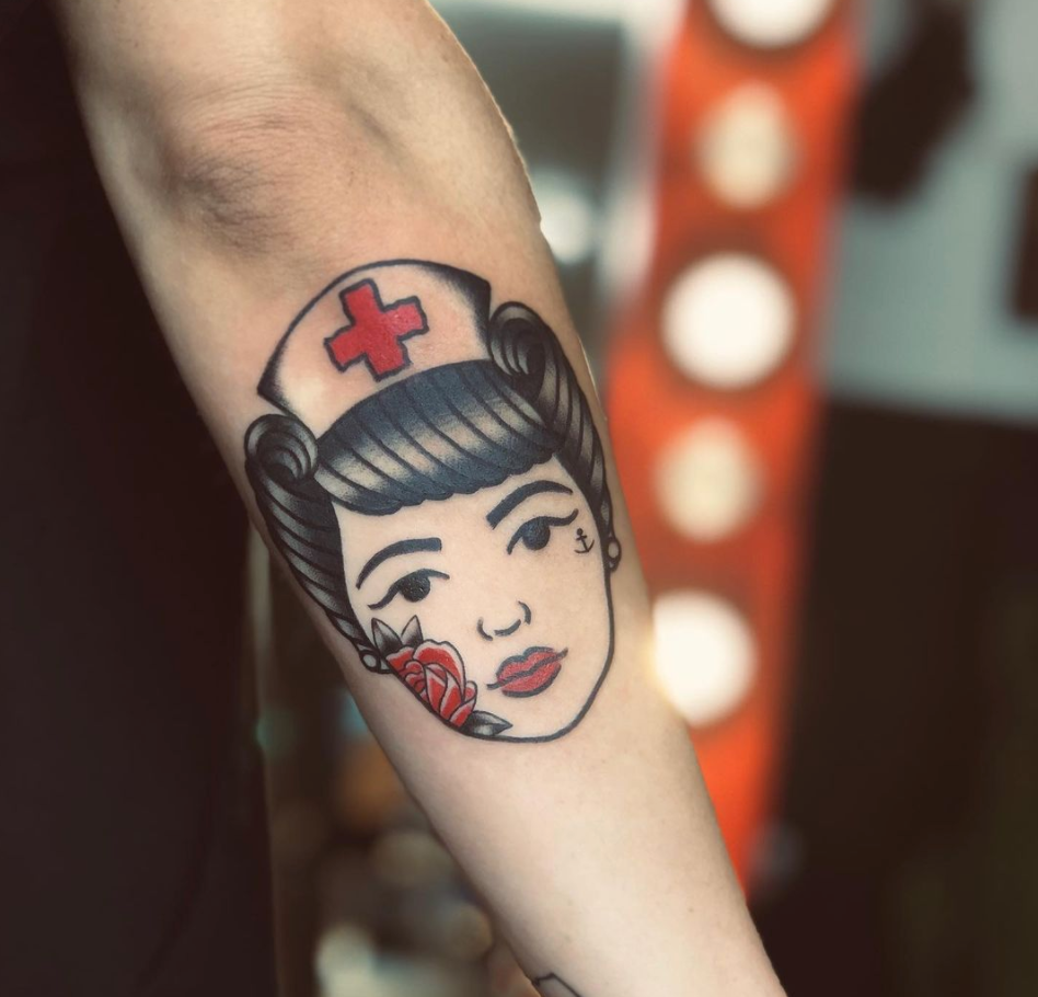 Nurse and rose color traditional forearm tattoo by Cavan Infante