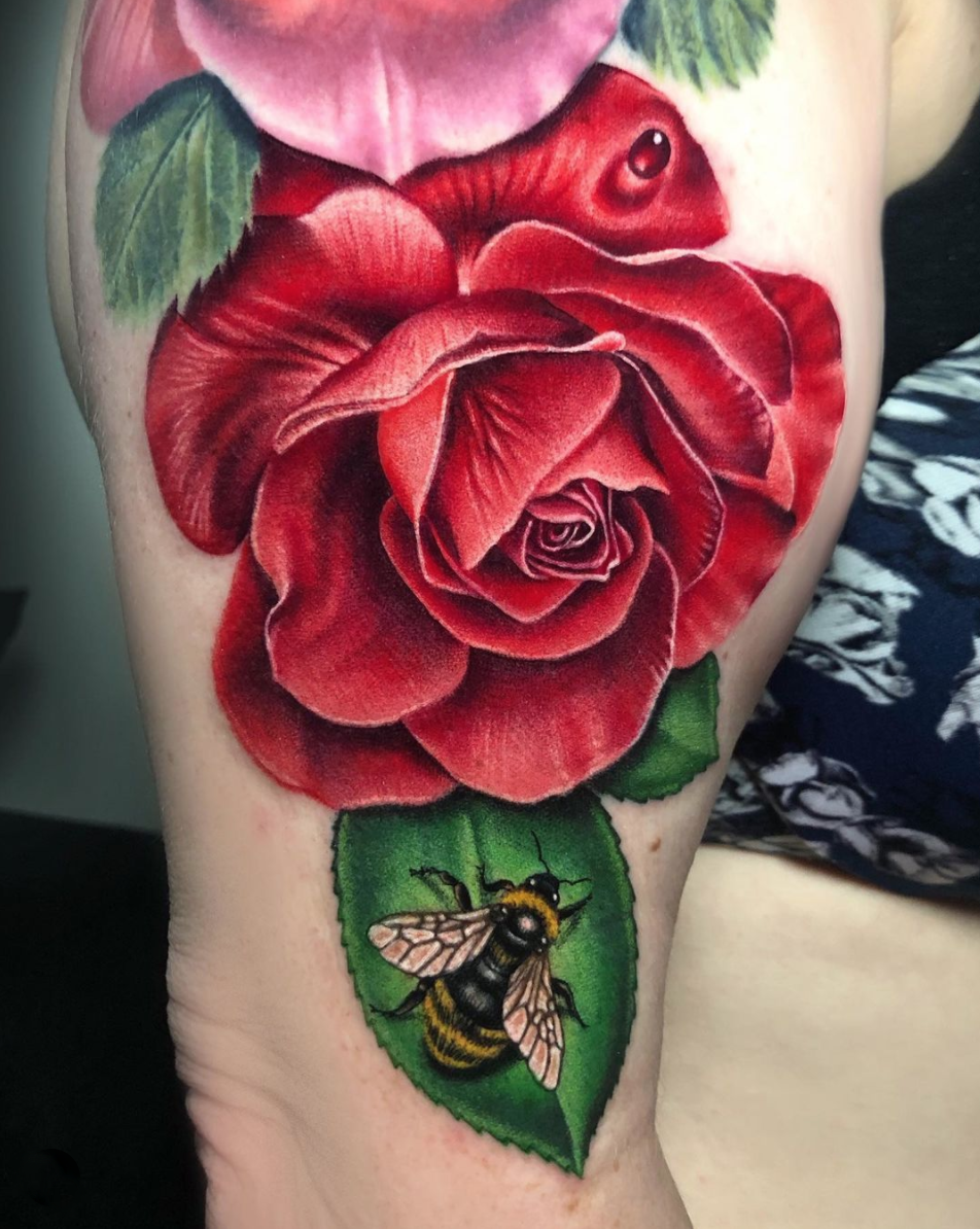 photorealism, color red rose and bee upper arm tattoo by Megan Massacre
