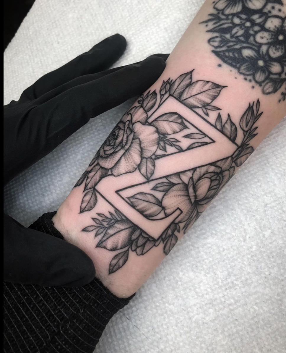 Floral negative space letter tattoo blackwork by Janice Danger
