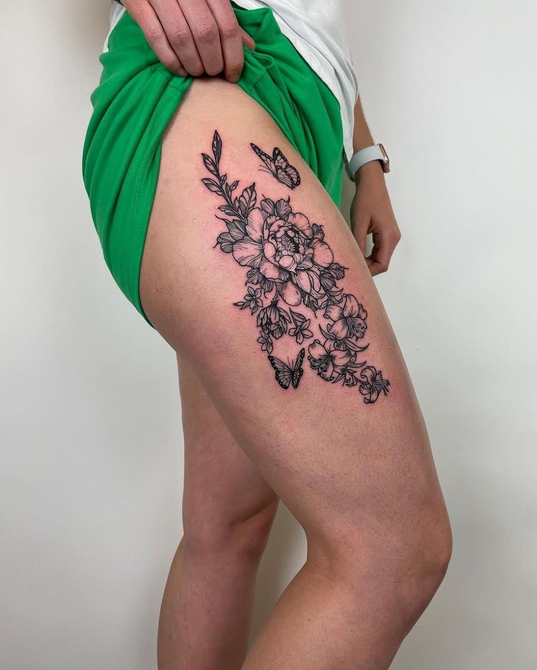 blackwork botanical thigh tattoo featuring flowers and butterflies by Mehak Basu