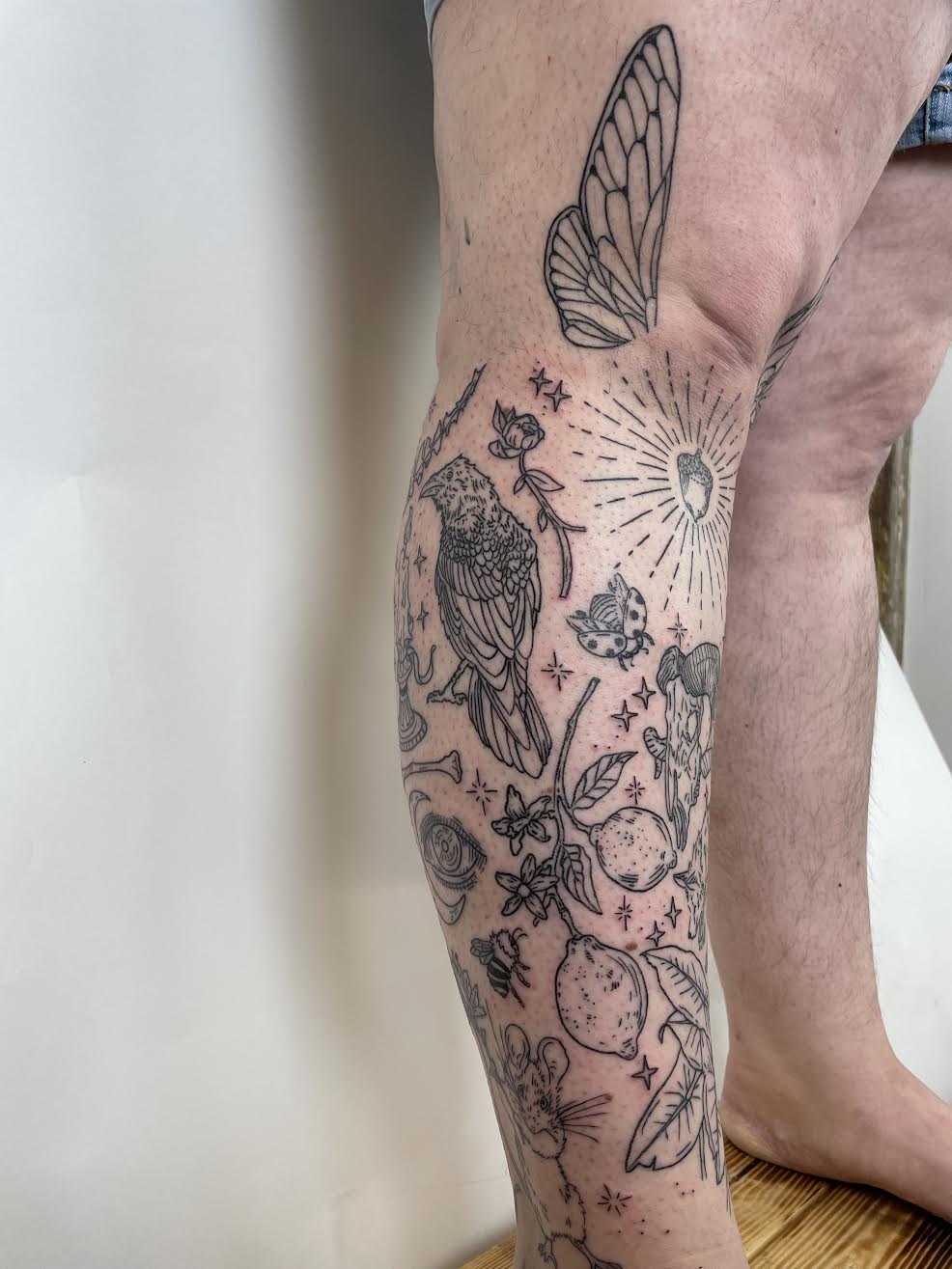 blackwork nature themed patchwork leg tattoo with lemons, bees, birds by Mehak Basu