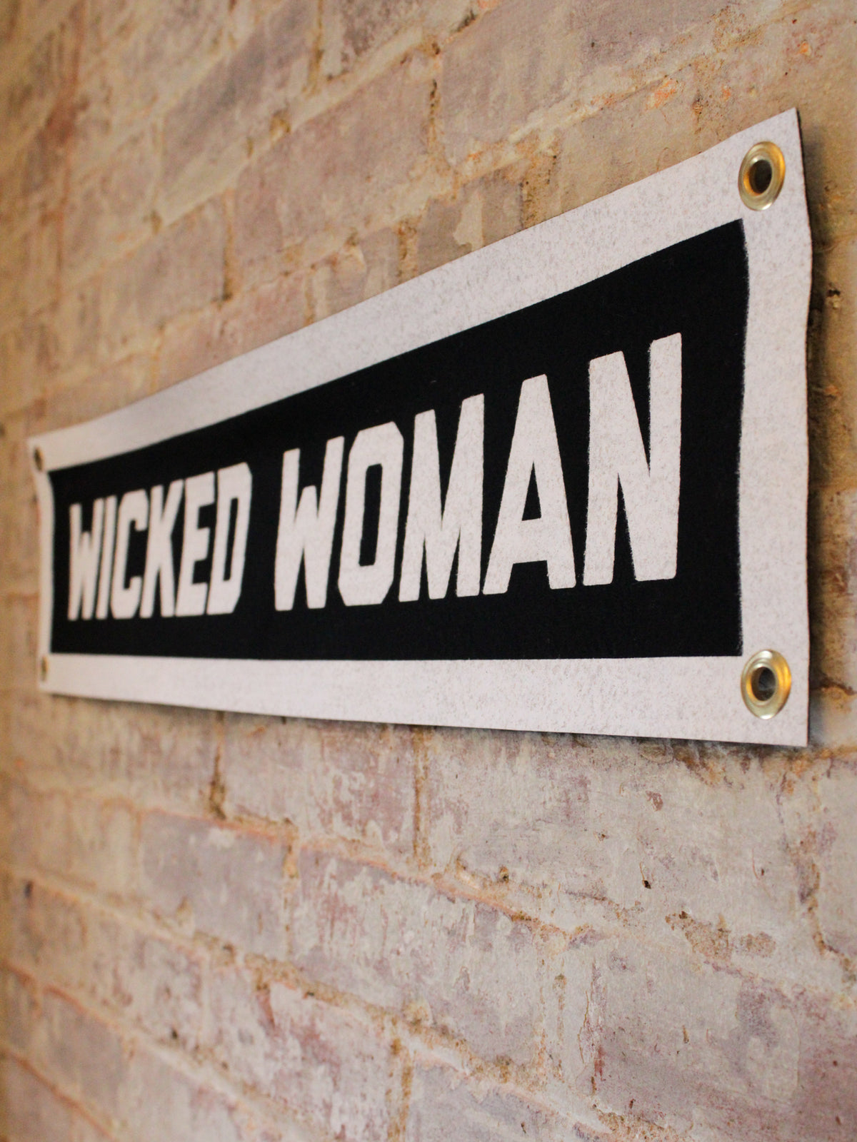 detail of black and white "wicked woman" banner with grommets