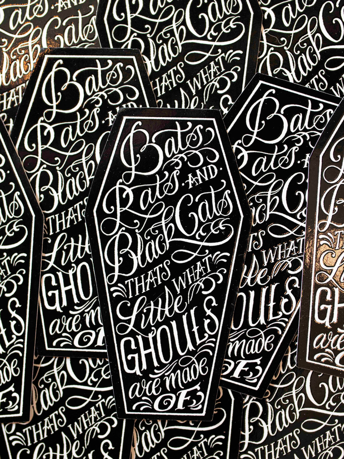 Coffin shaped stickers with text designed by Megan Massacre.