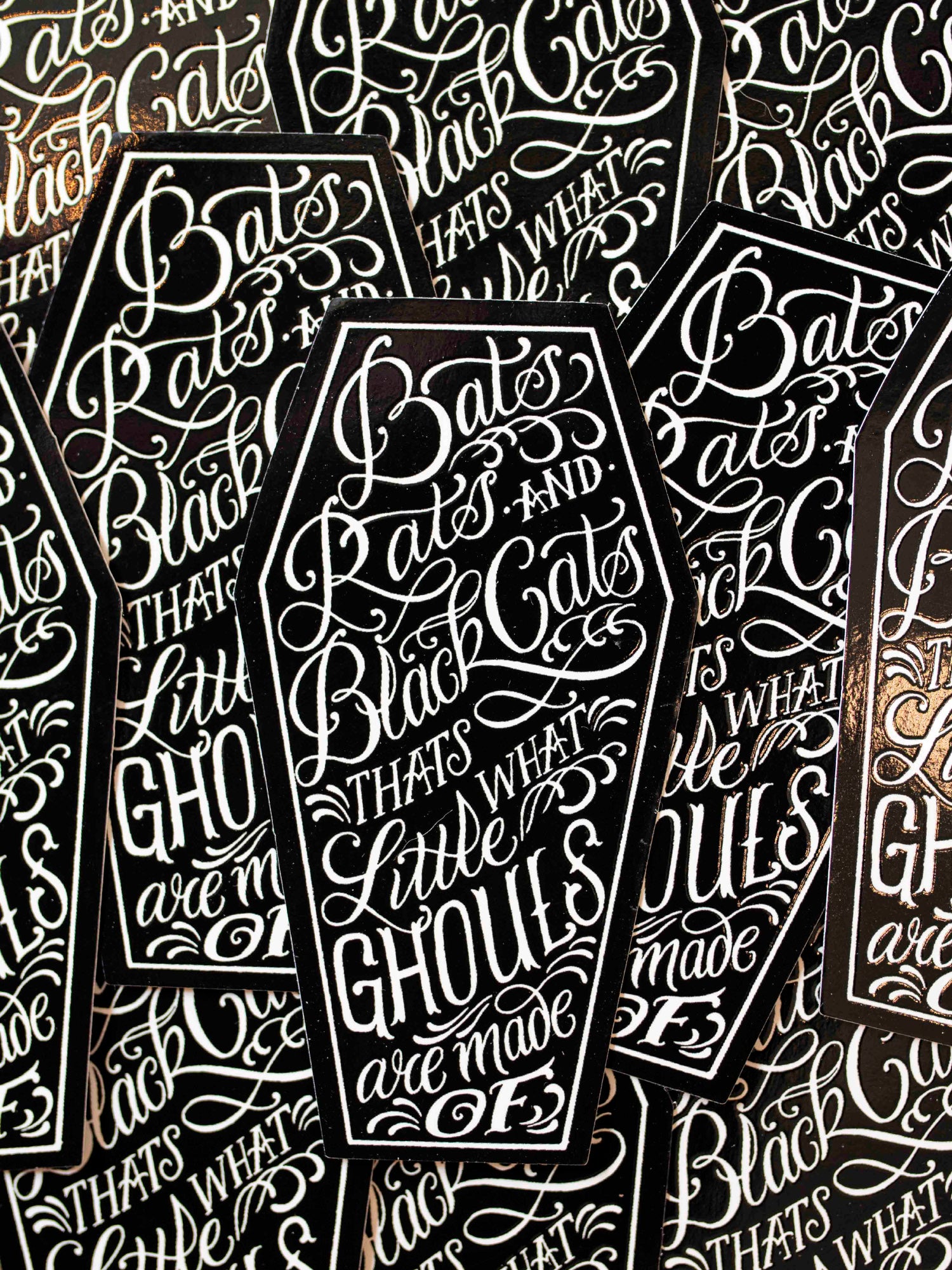 Coffin shaped stickers with text designed by Megan Massacre.