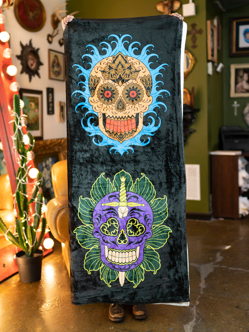 A black and white plush blanket with a colorful sugar skull design.