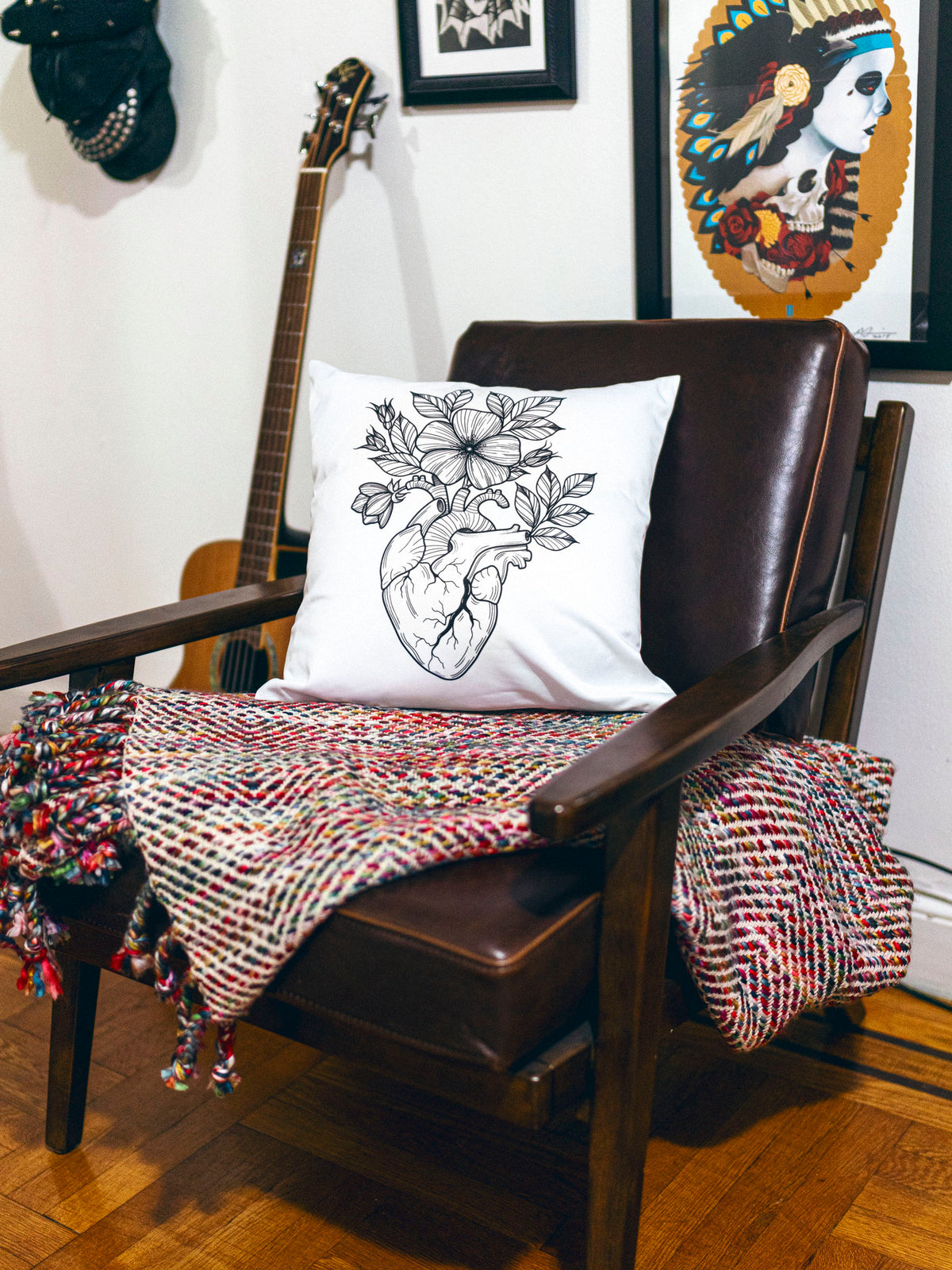 White throw pillow with black illustrative anatomical heart design by Janice Danger photographed in a homey setting. 
