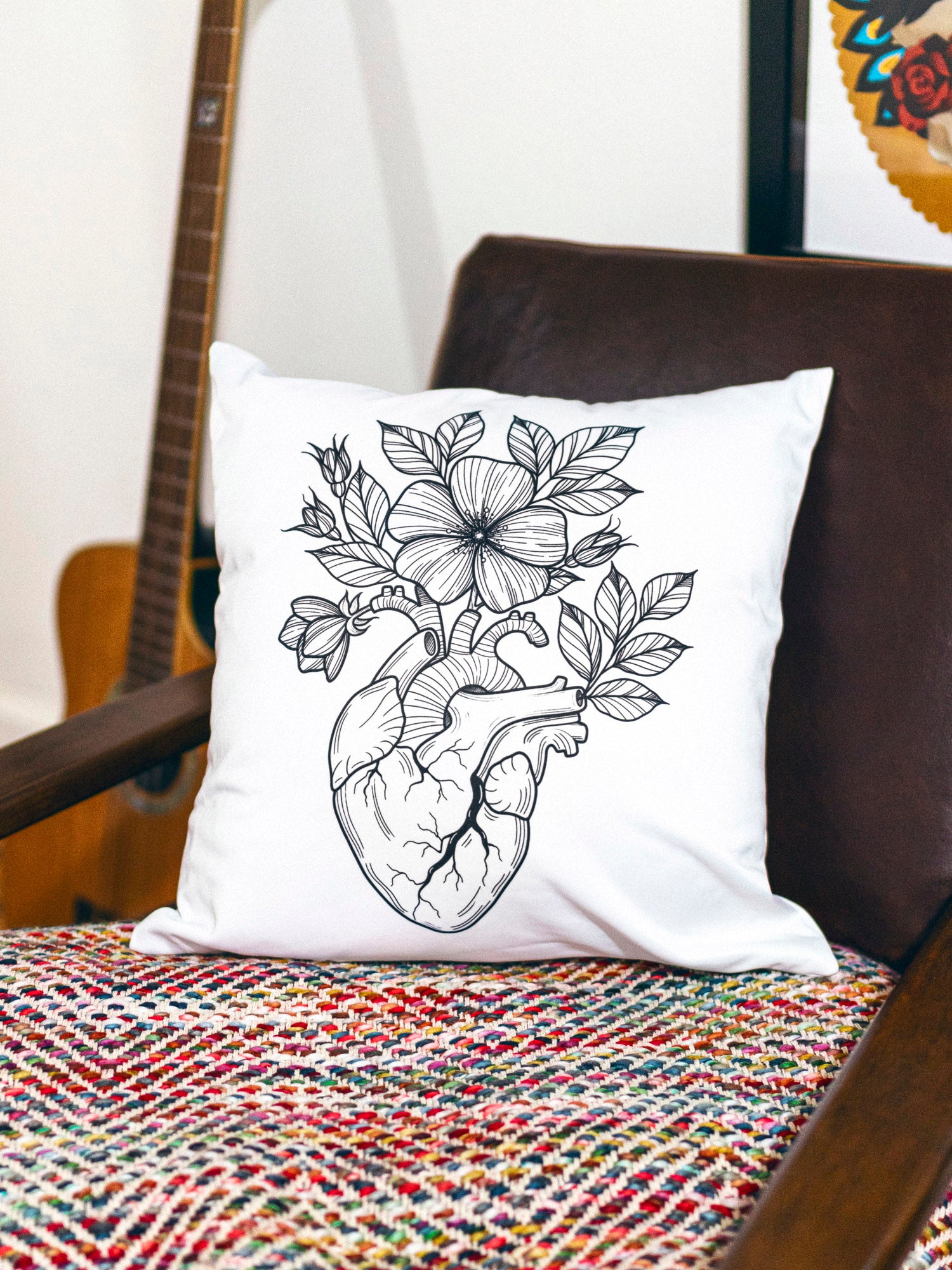 White throw pillow with black illustrative design by Janice Danger photographed in a homey setting. 