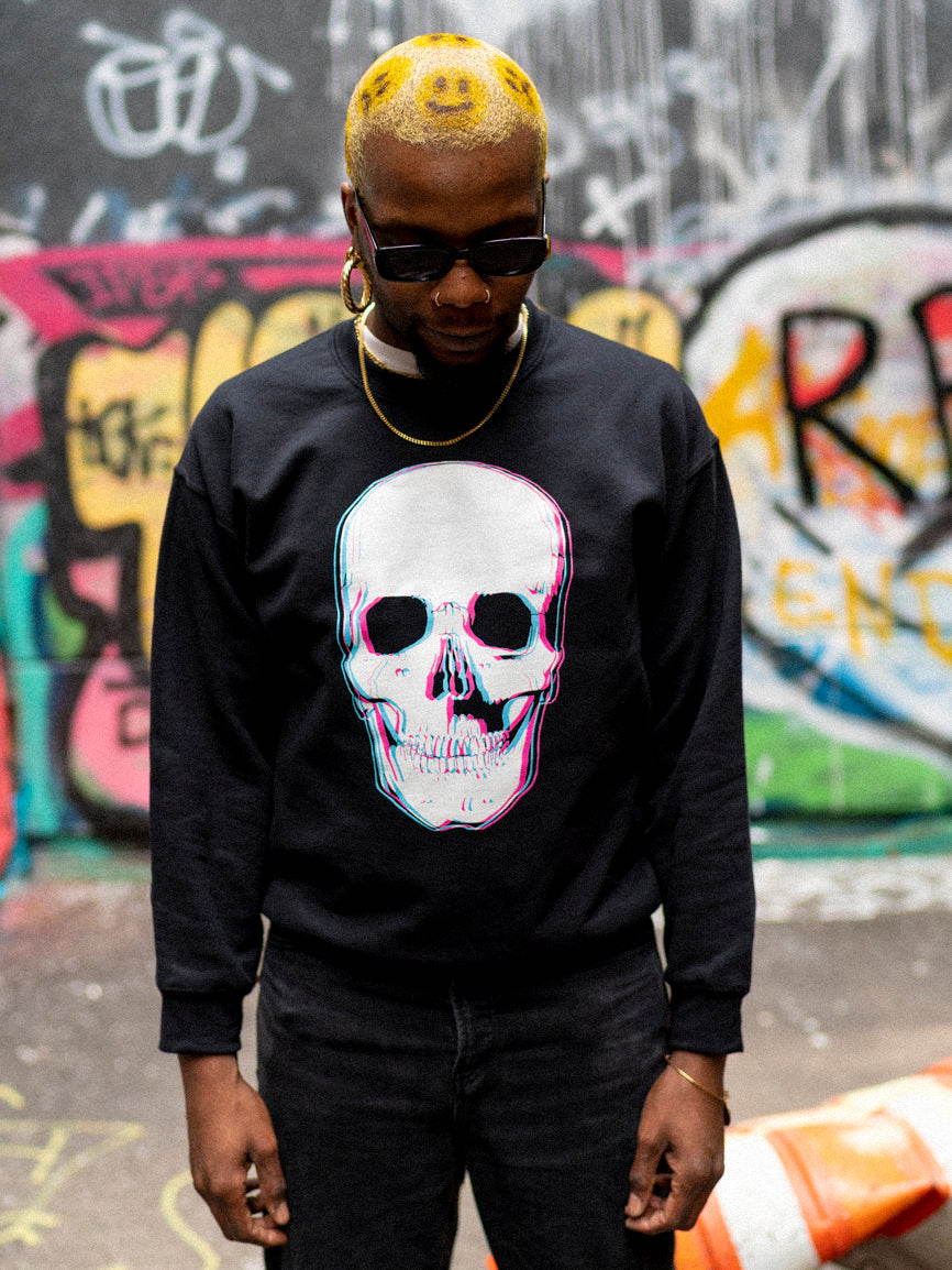A person wearing a black crewneck sweatshirt with a 3D style skull graphic on the front.