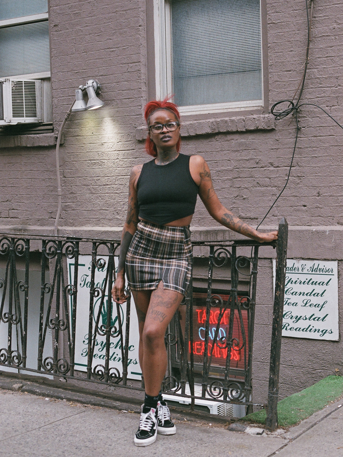 Person wearing a tan and black plaid mini skirt with the Soul Inside black cropped tank top. 