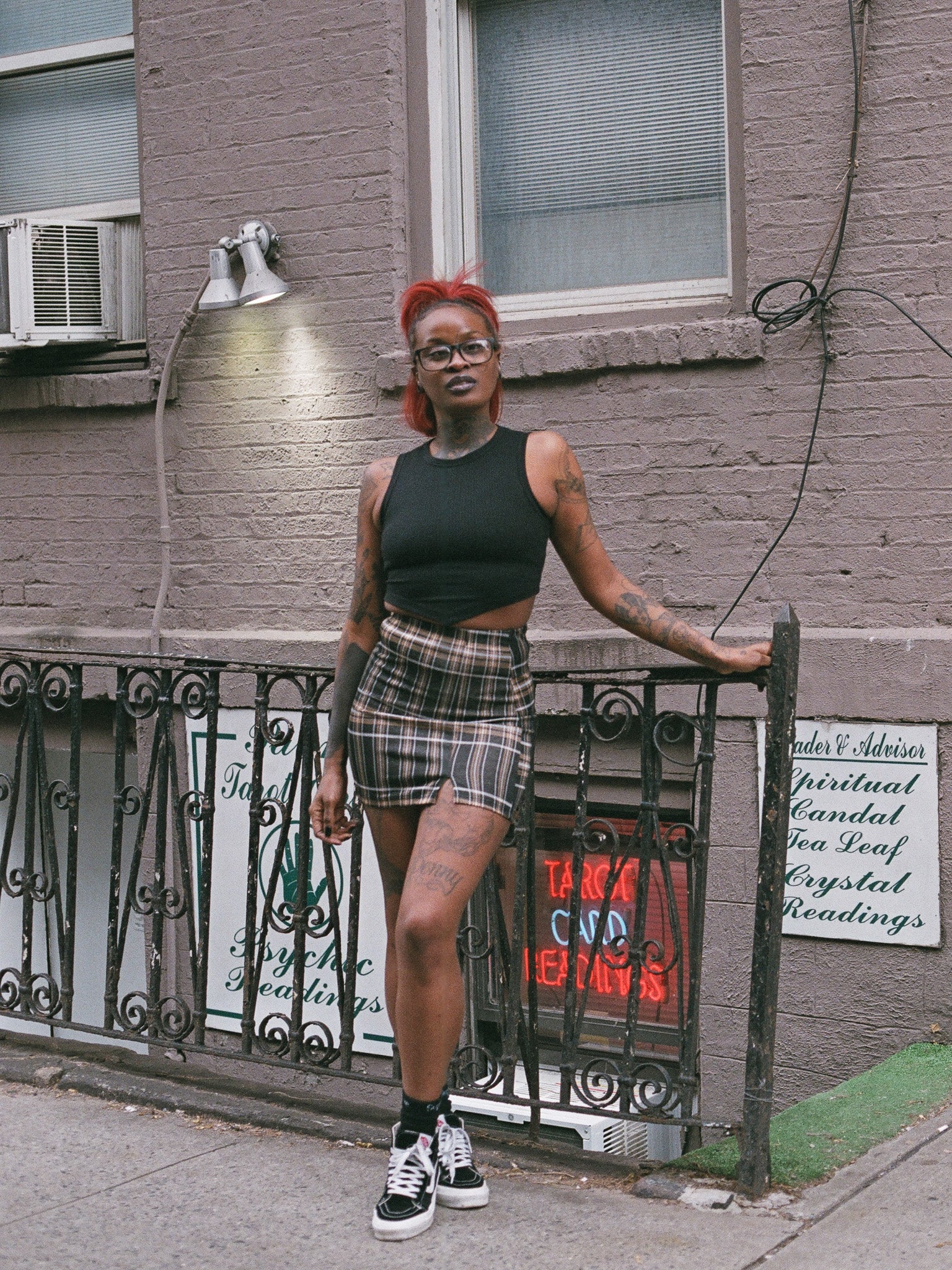 Person wearing a tan and black plaid mini skirt with the Soul Inside black cropped tank top. 
