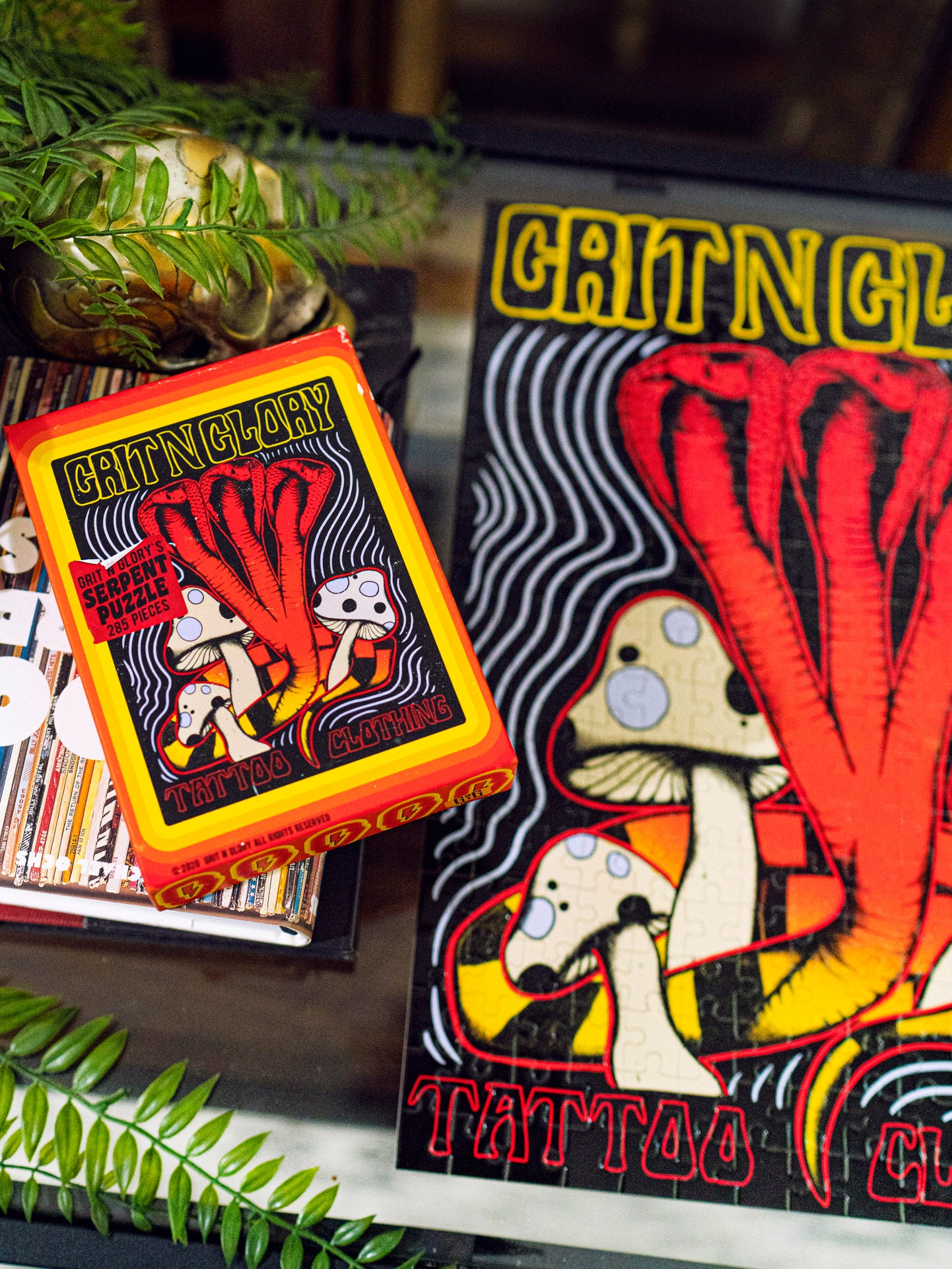 A puzzle box with a yellow and black multi headed cobra design, featuring the text 'Serpent Puzzle' and 'Grit N Glory'.